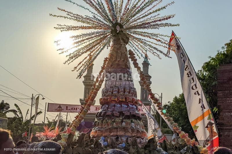 Di bawah terik sinar matahari, dengan bersemangat masyarakat mengarak gunungan menuju Masjid Wali Loram Kulon, Kecamatan Jati, Kabupaten Kudus.