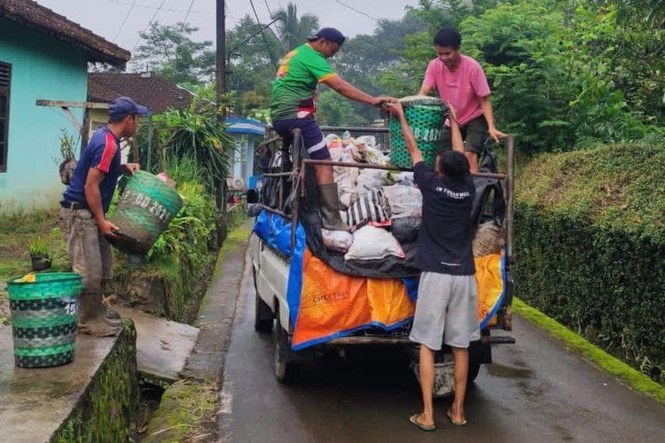 Para pemuda melakukan pengangkutan sampah warga. (Kompas/Dian Ade Permana)