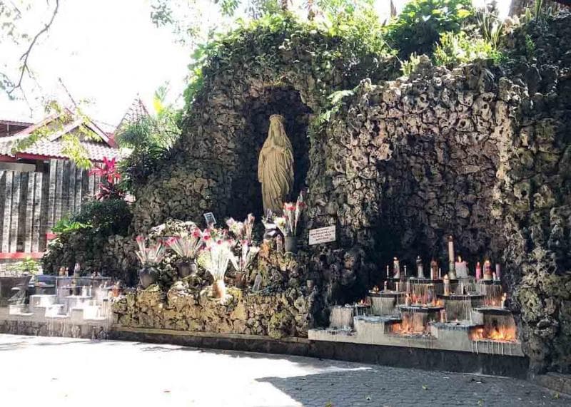 Pemandangan lilin dan bunga di Gua Maria Sendangsono. (Kevikepandiy.org)<br>