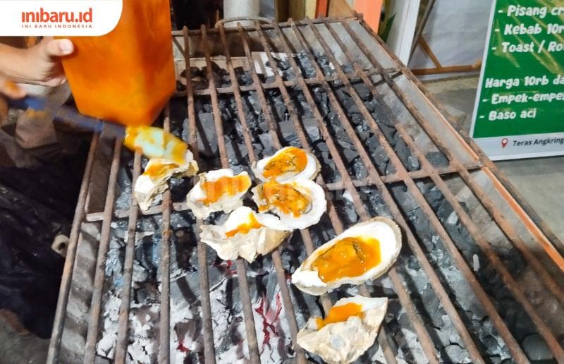 Tiram yang mulai matang, diolesi saus racikan. Tujuannya agar bumbu meresap dan membuat cita rasa tiram semakin enak.&nbsp;(Inibaru.id/ Ayu Sasmita)