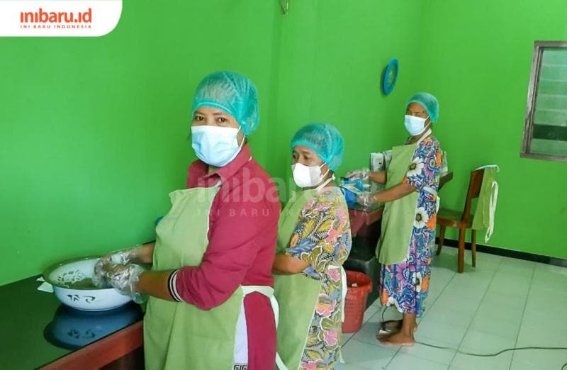 Beberapa pekerja menggunakan perlengkapan lengkap dalam menjaga kebersihan teh kelor di setiap bungkusnya. (Inibaru.id/ Ayu Sasmita)