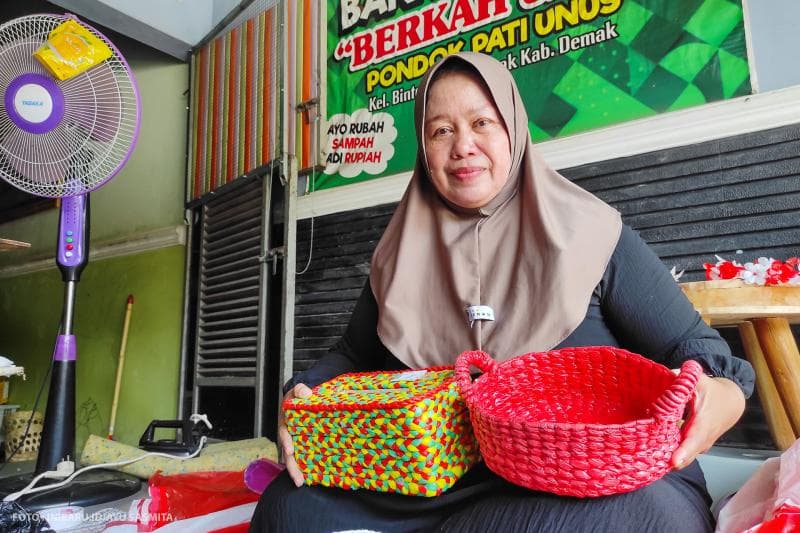 Ningsih, Ketua Kelompok Bank Sampah Berkah Jaya sedang memamerkan hasil kerajinan tangannya dari bahan dasar plastik bekas.&nbsp;
