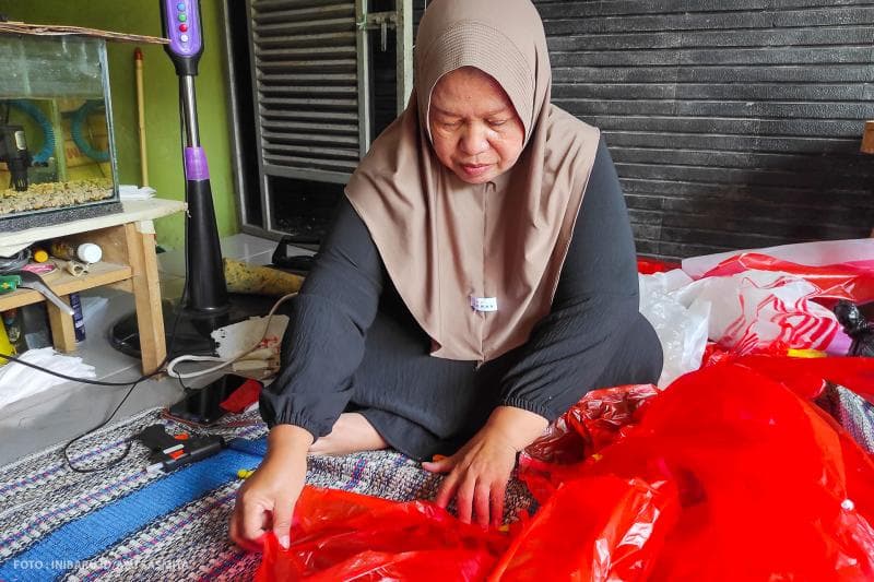 Ningsih sedang memilah plastik bekas untuk dijadikan bahan pembuatan gaun fashion show.&nbsp;