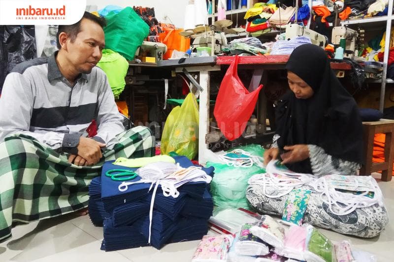 Taufik bersama istrinya tengah mnyortir masker yang sudah jadi. (Inibaru.id/Rafida Azzundhani)