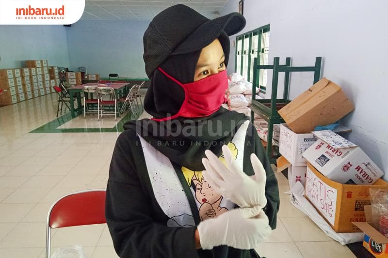 Seoranng sukarelawan yang sedang mengenakan sarung tangan. (Inibaru.id/ Zulfa Anisah)