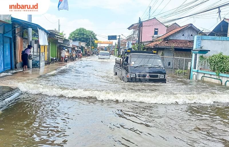 Kendaraan roda empat menerjang jalan yang digenangi banjir di Kabupaten Demak. (Inibaru.id/ Fitroh Nurikhsan)