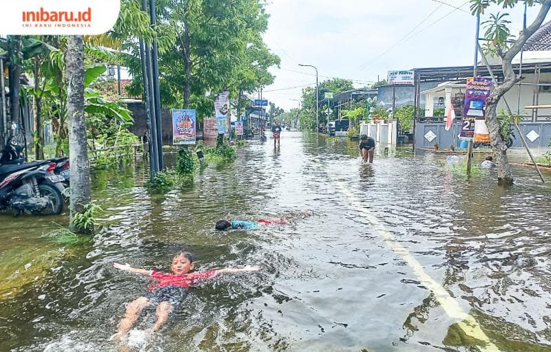 Anak-anak kecil memanfaatkan genangan banjir untuk bermain dan berenang. (Inibaru.id/ Fitroh Nurikhsan)
