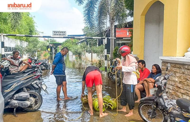 Seorang warga sedang mengamankan barang-barang penting salah satunya Gas Elpiji. (Inibaru.id/ Fitroh Nurikhsan)