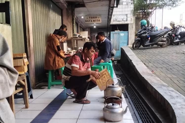 Suradi saat membakar roti yang dipesan pelanggan di kedainya. (IG/aris_tyan)