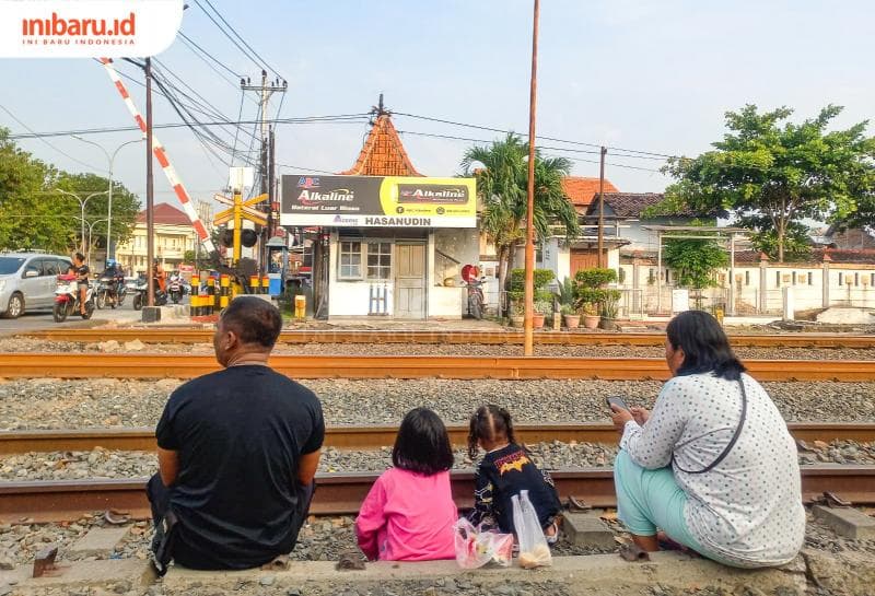 Potret orang tua momong anak hingga cucu di perlintasan kereta api Jalan Hasanudin Semarang. (Inibaru.id/Fitroh Nurikhsan)