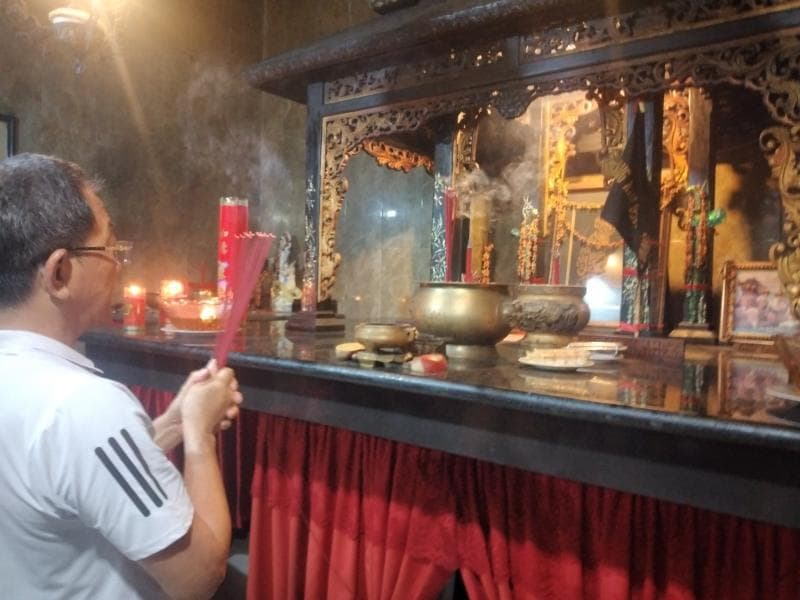 Peziarah yang tengah bersembahyang di altar yang bawahnya menjadi tempat Eyang Slamet bersemayam di Jalan Wotgandul No 30 Pecinan Semarang.&nbsp;(Inibaru.id/ Danny Adriadhi)