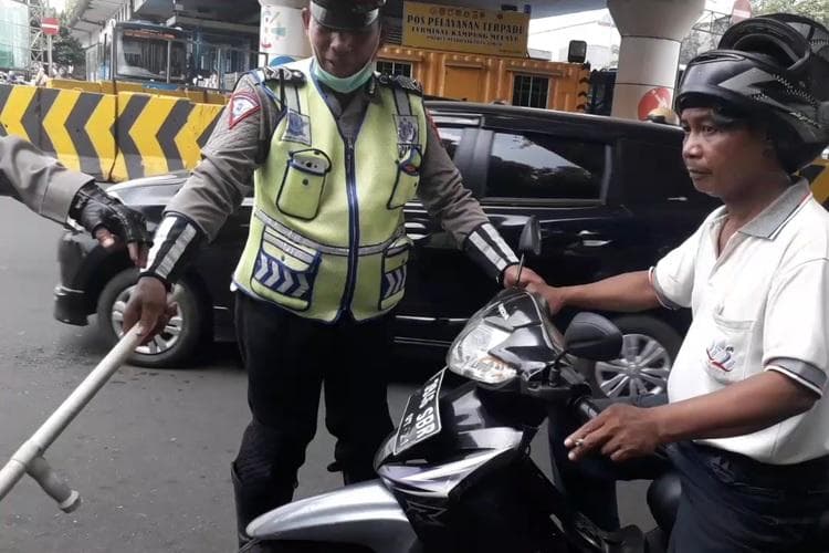 Polisi bisa memberhentikan pengendara yang merokok. (Kompas/Ardito Ramadhan)