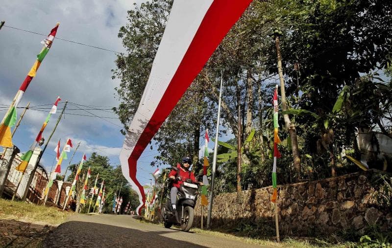 Umbul-umbul dan bendera merah putih yang menghiasi jalan di RT 3 RW 1 Kampung Bangong, Desa Pasirpogor, Bandung Barat. (Pikiranrakyat/Deni Armansyah)