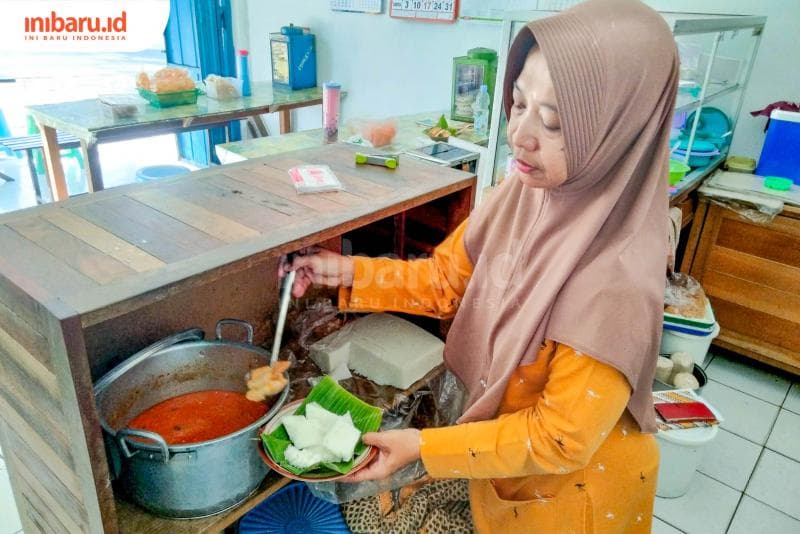 Cara penyajian puli kotokan di atas piring yg dialasi daun pisang lalu disir kuah kotokan tahu