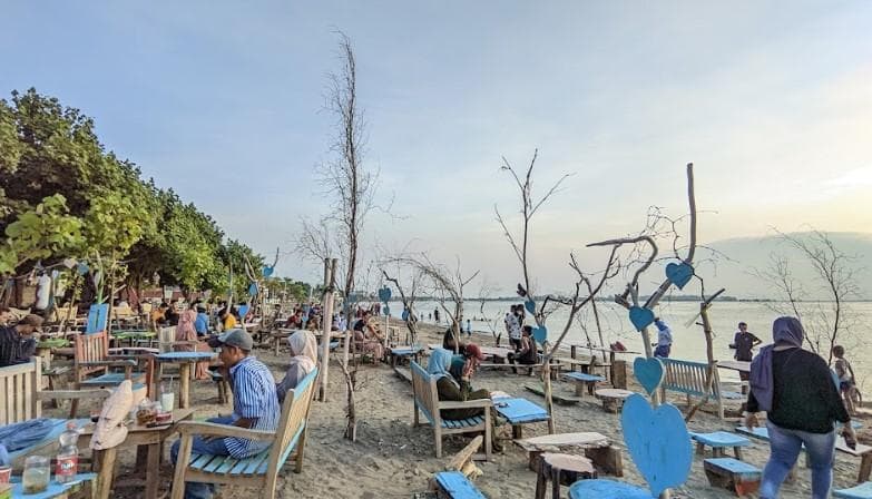 Wisatawan bersantai di tempat duduk di Pantai Sekembu. (Googleuser/Rifky Qodir)