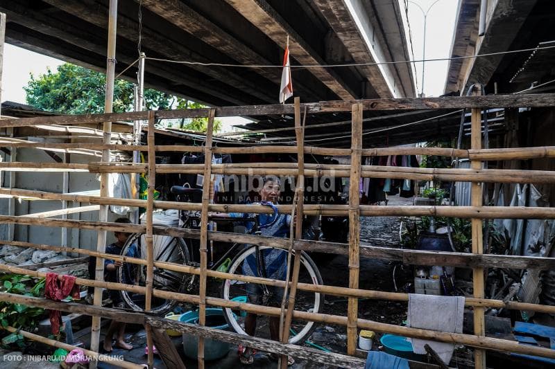 Seorang warga Kampung Cakrawala menjadikan pagar kayu untuk menggantung sepedanya.