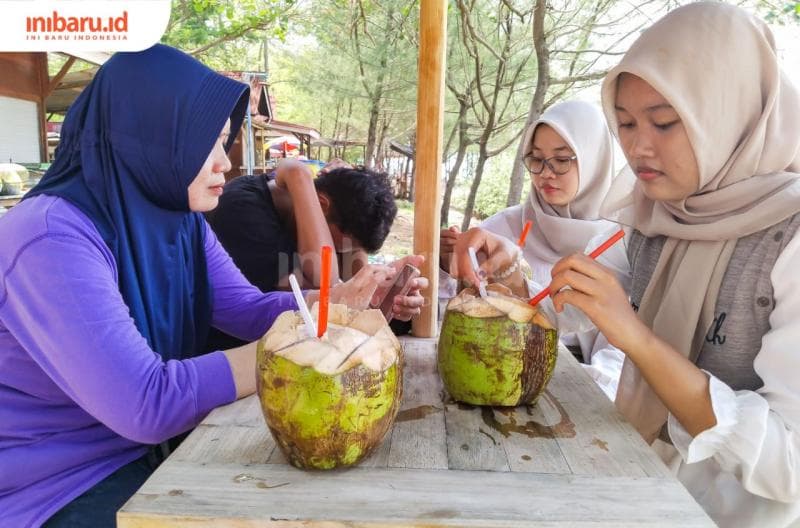 Pengunjung menikmati kesegaran es degan yang jadi menu kuliner andalan di Pulau Panjang. (Inibaru.id/ Sekarwati)