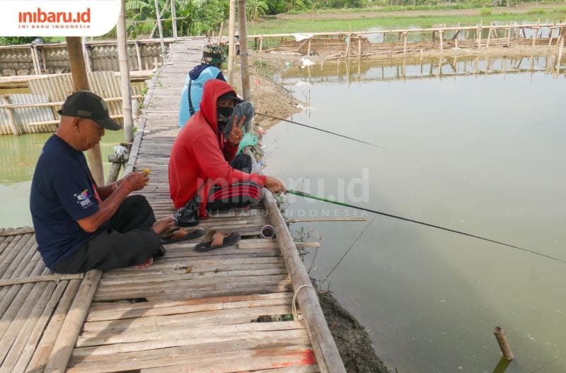 Para pemancing tengah menunggu umpannya disambar ikan di salah satu kolam di sebuah tempat pemancingan di Demak.&nbsp;(Inibaru.id/ Sekarwati)