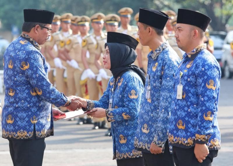 Pj Gubernur menyematkan penghargaan ke sejumlah Pegawai Negeri Sipil (PNS) yang telah mengabdi puluhan tahun dan siswa berprestasi. (Humas Pemprov Jateng)&nbsp;