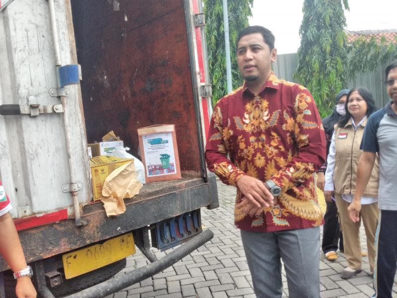 Kepala BPOM Semarang Lintang Purba Jaya tengah membuang obat kedaluwarsa ke truk dimusnahkan (Inibaru.id / Danny Adriadhi Utama)