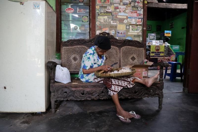 Mbok Marto kala di usia senja masih membantu proses produksi Mangut Lele Mbok Marto. (Kompas/Ferganata Indra Riatmoko)