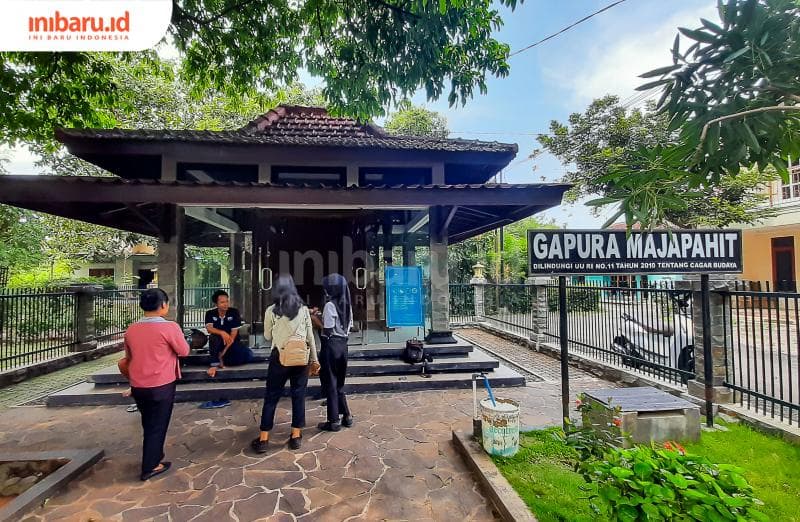 Siswa dari SMK sedang berbincang dengan Zaki untuk tugas sekolahnya di lokasi Gerbang Majapahit (Inibaru.id/Imam Khanafi)