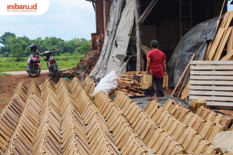 Pengrajin di Papringan sedang memindahkan genting yang telah selesai dijemur. (Inibaru.id/ Imam Khanafi)