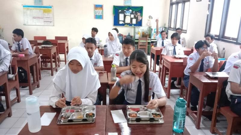 Siswa SMP 12 Semarang tengah menikmati makan bergizi gratis, Senin (6/1) (Inibaru.id/ Danny Adriadhi Utama)