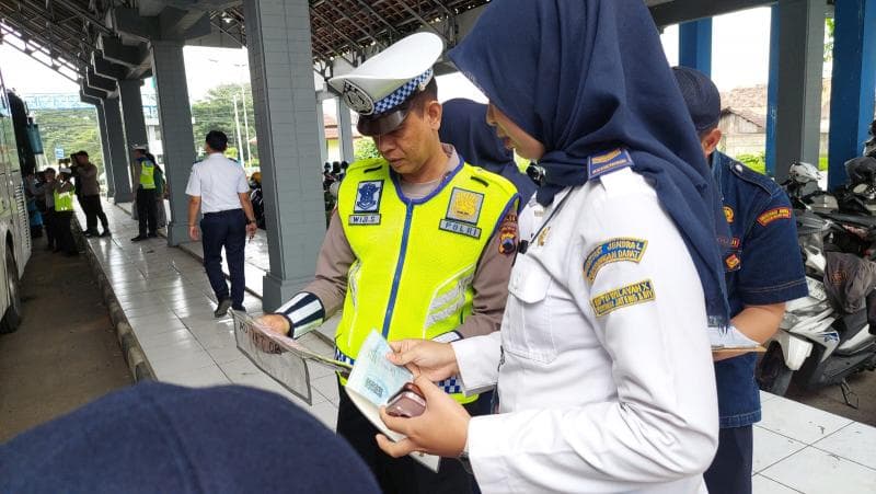 Petugas kepolisian dan Dishub tengah mencatat armada masuk daftar pelanggar saat pengecekan Ramp Check di terminal Mangkang. (Humas Polda Jateng)