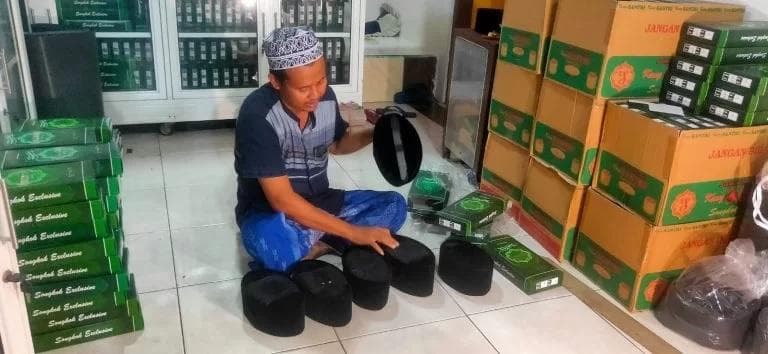 Nur Yasin menunjukkan sejumlah model Peci Kang Santri. (Kanal Muria/Iby)