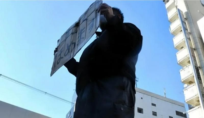 Paman Pujian saat menunggu pelanggannya di depan stasiun. (Asahi)