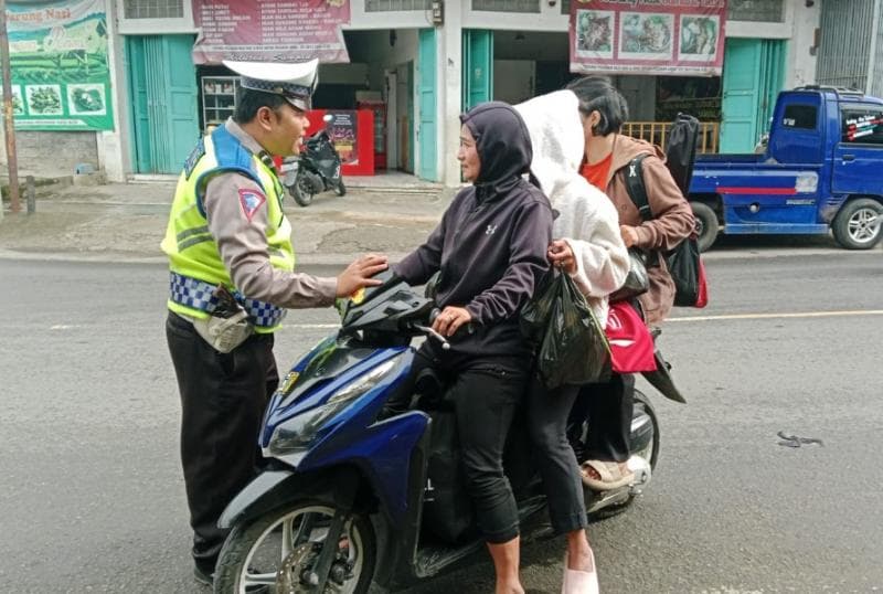 Berboncengan tiga saat naik sepeda motor melanggar peraturan lalu lintas. (Kimcipedes)