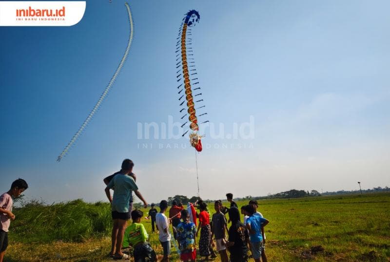 Segerombolan anak menerbangkan&nbsp; layang-layang naga (Inibaru.Id/Alfia Ainun Nikmah)