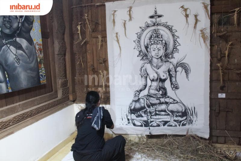 Putut sedang membenarkan karyanya di ruang pamer. (Inibaru.id/Imam Khanafi)