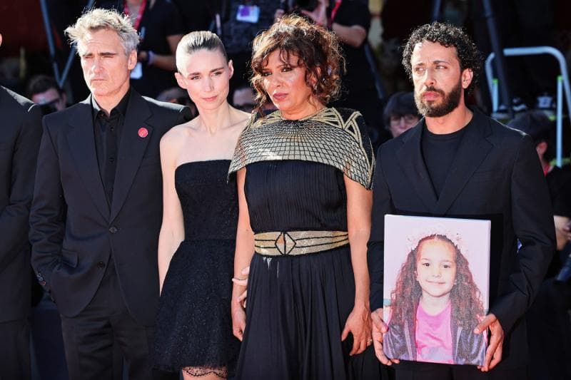 Pemeran dan produsen 'The Voice of Hind Rajab' membawa foto sang anak yang jadi korban genosida di Gaza. (CNBC)