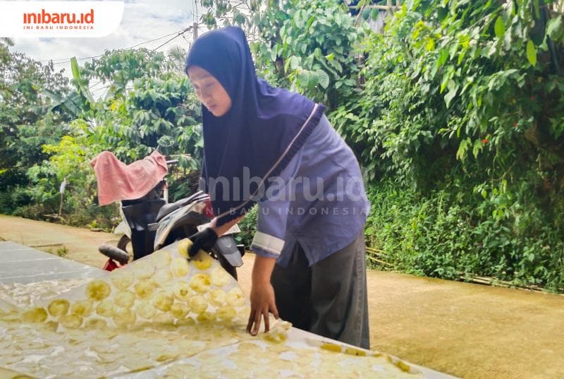 Zumrotul saat mengeringkan emping melinjo yang masih hangat. (Inibaru.id/ Sekarwati)