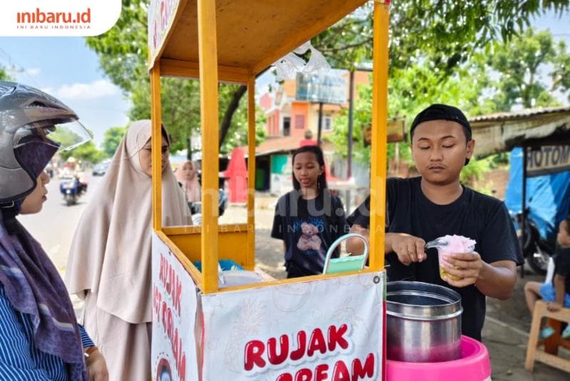 Suami Lailiyah sedang mengambil es krim dari tong es krim. (Inibaru.Id/ Alfia Ainun Nikmah)