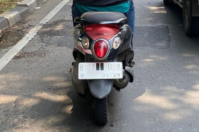 Ilustrasi: Menutup pelat nomor kendaraan bermotor. (Kompas/Lidia Pratama Febrian)