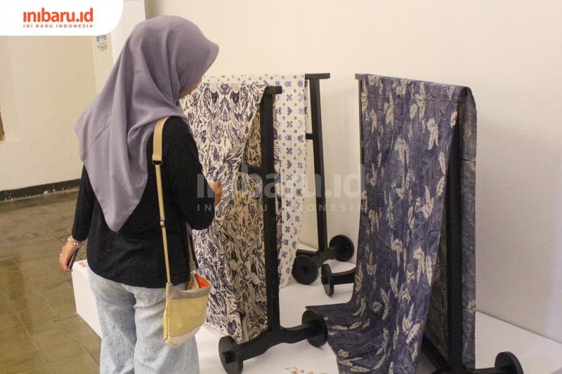 Seorang pengunjung melihat repro batik karya Kartini yang dipamerkan. (Inibaru.id/Imam Khanafi)