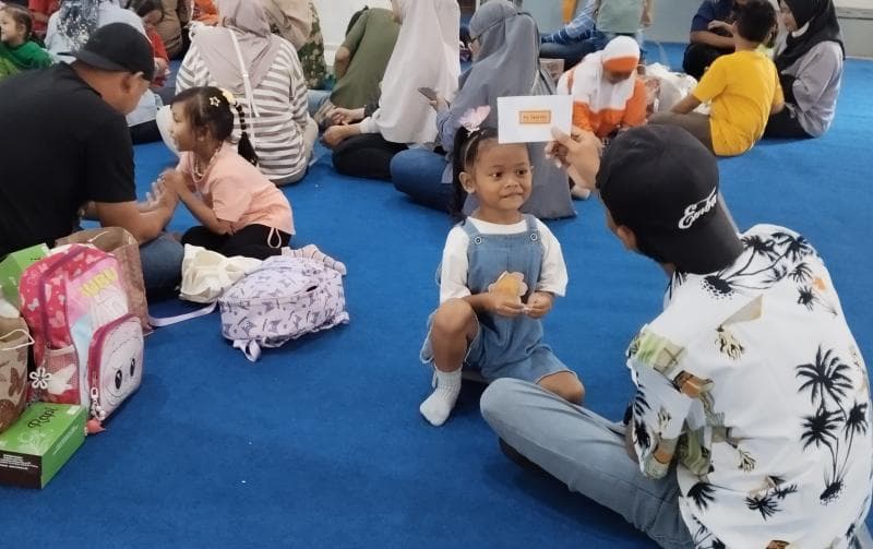 Seorang ayah sedang bermain tebak gambar dalam acara Main Sama Bapak di Wisma Perdamaian Semarang. (Inibaru.id/Sundara) 