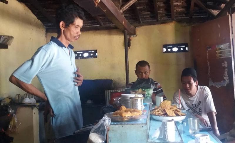 Wak Nasir saat melayani pelanggan di warungnya. (Anwar Mf)