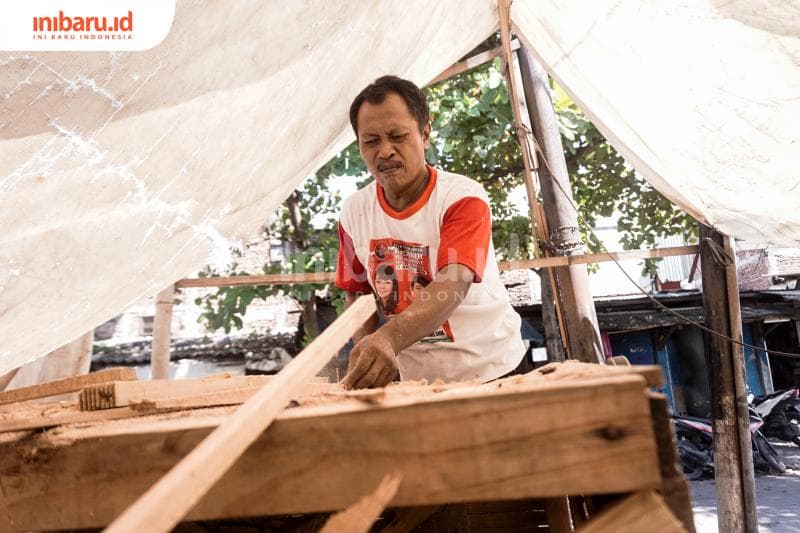 Hadi membuat keranjang parsel secara manual. (Inibaru.id/ Audrian F)<br>