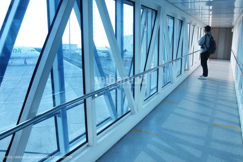Calon penumpang pesawat mengamati situasi bandara yang sangat sepi.