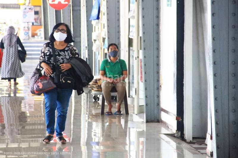 Calon penumpang Kereta Api berjalan sendirian di Stasiun Tawang.