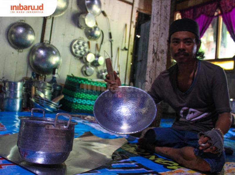 Triyanto, pengrajin disabilitas yang pernah mengikuti pelatihan mengolah logam yang diinisiasi Ershad menunjukkan peralatan dapur yang dibuatnya dari logam. (Inibaru.id/ Audrian F)<br>
