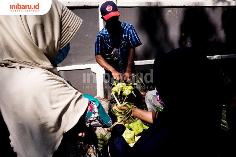 Biar aman saat berbelanja selongsong ketupat para pembeli melakukan sejumlah siasat. (Inibaru.id/ Audrian F)<br>