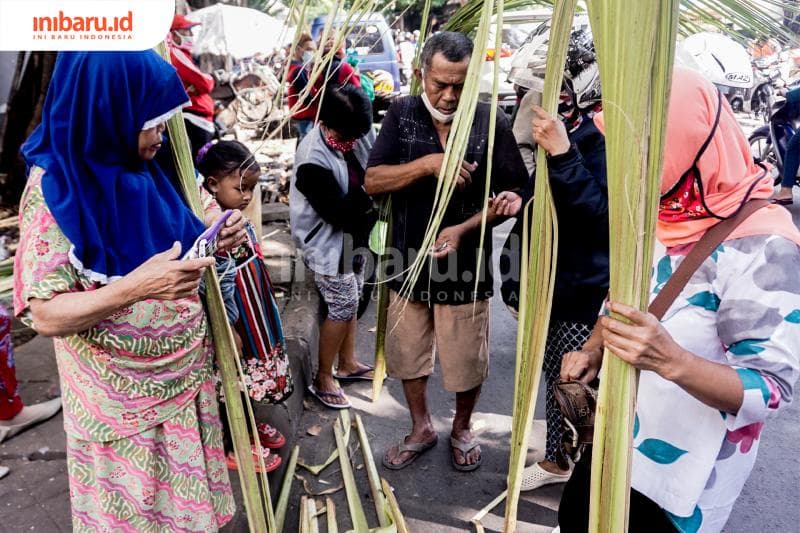 Para pelanggan sedang bertransaksi membeli janur. (Inibaru.id/ Audrian F)<br>