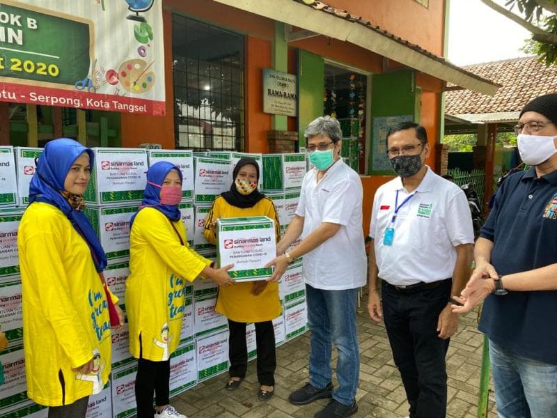 Para petinggi Sinar Mas Lang menyerahkan bantuan berupa paket bahan makanan yang secara simbolis diterima perwakilan warga. (Sinar Mas Land)&nbsp;