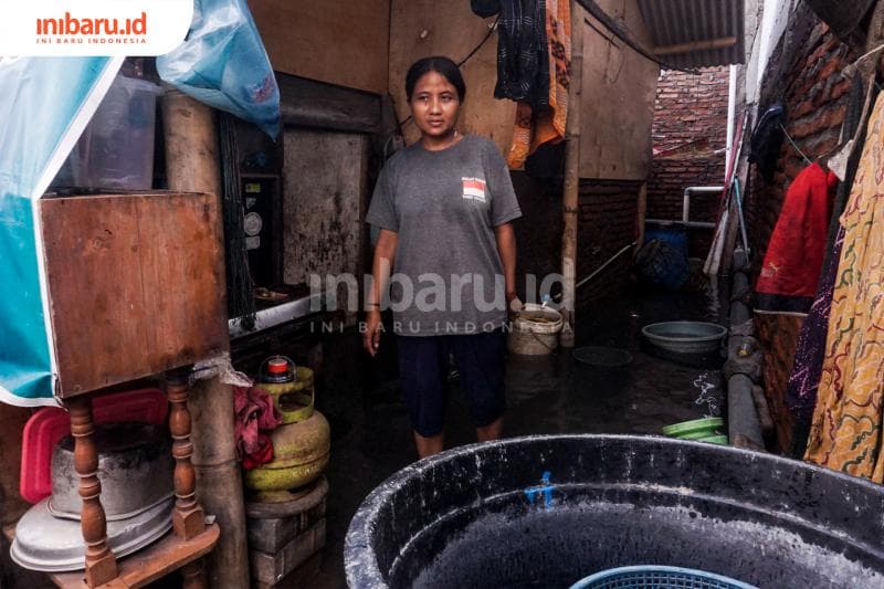 Puji Agustin menunjukan dapur yang tergenang air banjir rob Semarang. (Inibaru.id/ Audrian F)<br>