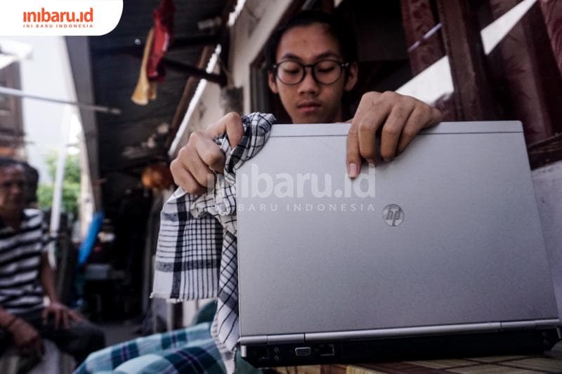 Ricky mengelap laptop agar selalu bersih. (Inibaru.id/ Audrian F)<br>